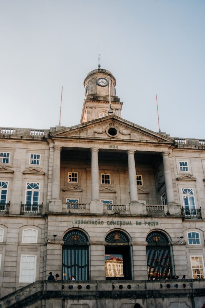 Ornate stone building with a clock tower and columns.